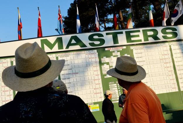 Patron walk past the main leader board at sunrise at the start of the 2015 Masters Tournament at Augusta National Golf Club in Augusta, Georgia on April 9, 2015.  MAS20150409120 KEVINxDIETSCH