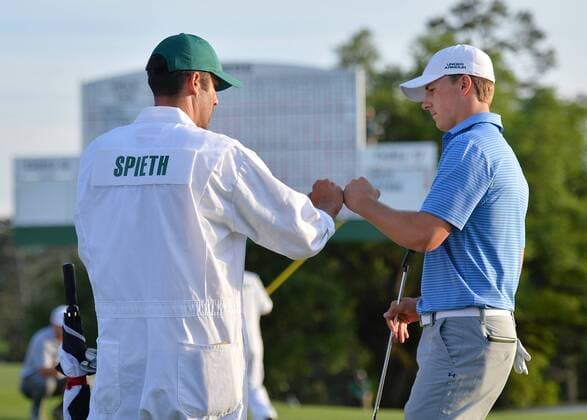 Jordan Spieth celebrates with caddie Michael Greller after making a putt for par in the 18th hole in the third round of the 2015 Masters Tournament at Augusta National Golf Club in Augusta, Georgia on April 11, 2015.  AUG20150411149 KEVINxDIETSCH