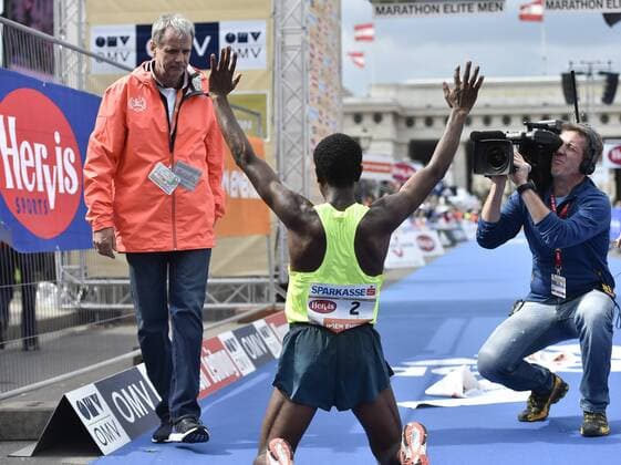 ATHLETICS - VCM 2015 VIENNA,AUSTRIA,12.APR.15 - ATHLETICS, RUNNING - Vienna City Marathon. Image shows Wolfgang Konrad (VCM), the rejoicing of Sisay Lemma (ETH) and a cameraman. GEPAxpictures xM.xHoermandinger 