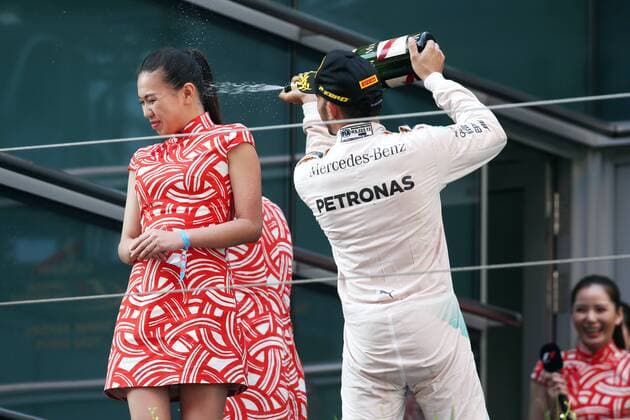 Britain s Lewis Hamilton of Mercedes, right, sprays champagne on the face of a hostess during the award ceremony of the 2015 Formula 1 Chinese Grand Prix at the Shanghai International Circuit in Shanghai, China, 12 April 2015. Chinese Grand Prix in Shanghai  20150412_10479
