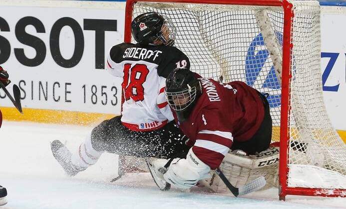 16.04.2015 Arena Zug , SCHWEIZ, Herren IIHF Eishockey Weltmeisterschaft U18 Kanada - Lettland Glenn Deven Sideroff (Kanada U18) prallt in Torwart Denijs Romanovskis (Lettland U18) ; Zweikampf , Aktion 