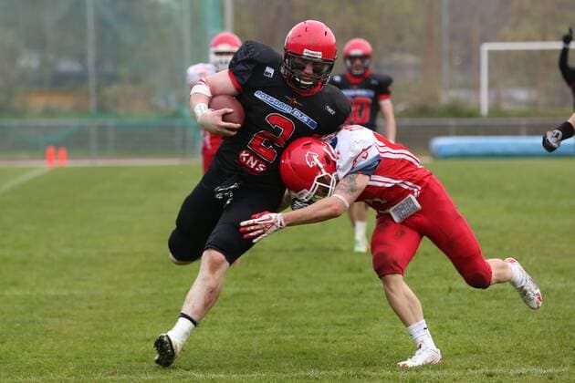 Rostock, 25. April 2015 American Football, Saison 2015 2016, German Football League 2, 1. Spieltag, Lübeck Cougars - Potsdam Royals: Jamie Dale (Lübeck Cougars, 4) stoppt Cody Seibel (Potsdam Royals, 2) kurz vor der Endzone