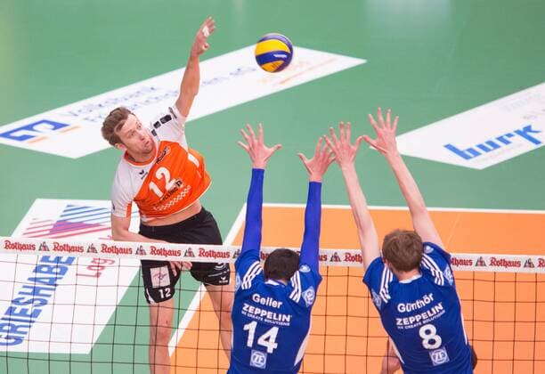 Friedrichshafen, Deutschland, 26.04.2015: Volleyball Bundesliga Playoffs Finale Spiel 3 (Best of Five) Saison 2014 2015 - VfB Friedrichshafen - Berlin Recycling Volleys. Paul Carroll (BR Volleys 12) gegen den Block aus Baptiste Geiler (Friedrichshafen 14), Max Günthör Guenthoer (Friedrichshafen 8)