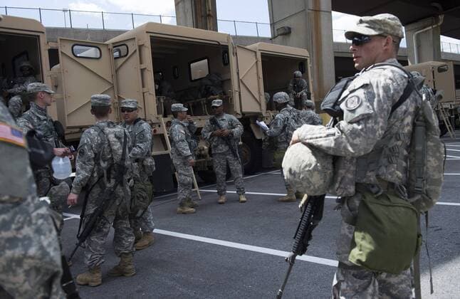 Members of the Maryland National guard stage in a parking lot near Orioles Park in Camden Yards in Baltimore, Maryland on April 29, 2015. Protesters continue to march throughout Baltimore in the wake of Freddie Gray s death. The late 25-year-old died earlier this month from a spinal injury while in police custody.  BAL20150429358 KEVINxDIETSCH
