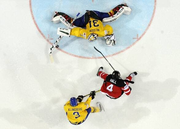 Sweden s John Klingberg tries to stop Canada s Taylor Hall, center, as Sweden s goalkeeper Anders Nilsson, right, blocks a shot during the Hockey World Championships Group A match in Prague, Czech Republic, Wednesday, May 6, 2015. (CTKxPhoto MichalxKamaryt,xRomanxVondrous) CTKPhotoP201505061080101  vnd