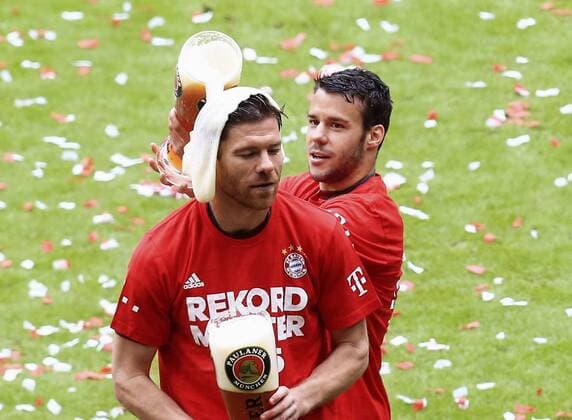 23.05.2015, Fussball 1.Bundesliga 2014 2015, 34.Spieltag, FC Bayern München - 1.FSV Mainz 05, in der Allianz-Arena München, Ehrung des Deutschen Meisters FC Bayern nach dem Spiel. Juan Bernat (Bayern) schüttet Weissbier über Xabi Alonso (Bayern München). 