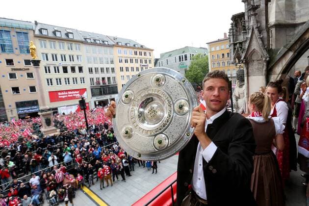 MUNICH, GERMANY - MAY 24: Thomas Müller of FC Bayern München holds the German Championship winners trophy as the team celebrate winning the German Championship title on the town hall balcony at Marienplatz on May 24, 2015 in Munich, Germany. - Thomas Müller