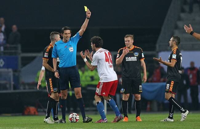 28.05.2015, Fussball Saison 2014 2015, Relegation Hinspiel, Hamburger SV - Karlsruher SC in der IMTECH-Arena Hamburg, v.l. Jonas Meffert (Karlsruhe) , Schiedsrichter Deniz Aytekin zeigt Gojko Kacar (Hamburg) die gelbe Karte , Rouwen Hennings (Karlsruhe) , Manuel Torres (Karlsruhe) 