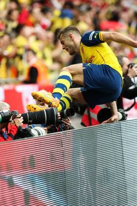 Football - 2015 FA Cup Final - Arsenal vs. Aston Villa. Arsenal s Jack Wilshere leaps over the advertising boards and heads into the crowd at Wembley Stadium COLORSPORT DANIEL BEARHAM  AST_ARS