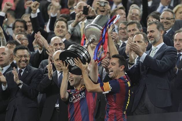 King Felipe VI of Spanin gives the cup to Barcelona s Xavi Hernandez and Andres Iniesta after winning the 2014-15 Copa del Rey final match between Barcelona and Athletic de Bilbao at Camp Nou stadium in Barcelona, Spain. May 30, 2015.  (2015053000026)
