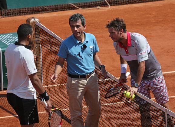 The chair umpire (C) explains a ruling to both players during the French Open men s semifinal match between Jo-Wilfried Tsonga (L) of France and Stan Wawrinka of Switzerland at Roland Garros in Paris on June 5, 2015.  PAR20150605723 DAVIDxSILPA