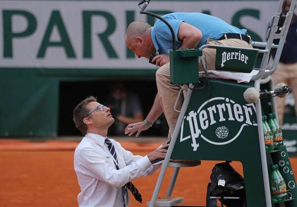 Tournament officials discuss stopping play during the French Open men s semifinal match between Novak Djokovic of Serbia and Andy Murray of Great Britain at Roland Garros in Paris on June 5, 2015. Play was suspended due to rain and darkness with Djokovic leading 6-3, 6-3, 5-7, 3-3.  PAR20150605763 DAVIDxSILPA