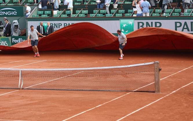 Ground crew pull a tarp onto the court after play was stopped during the French Open men s semifinal match between Novak Djokovic of Serbia and Andy Murray of Great Britain at Roland Garros in Paris on June 5, 2015. Play was suspended due to rain and darkness with Djokovic leading 6-3, 6-3, 5-7, 3-3.  PAR20150605764 DAVIDxSILPA