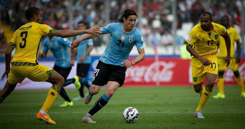 (150614) -- ANTOFAGASTA, June 14, 2015 -- Edinson Cavani (C) of Uruguay vies with Michael Hector of Jamaica during their Group B match at Copa America 2015, in Antofagasta, Chile, on June 13, 2015. Uruguay won 1-0. ) (SP)CHILE-ANTOFAGASTA-COPA AMERICA-GROUP B-URUGUAY VS JAMAICA PedroxMera 
