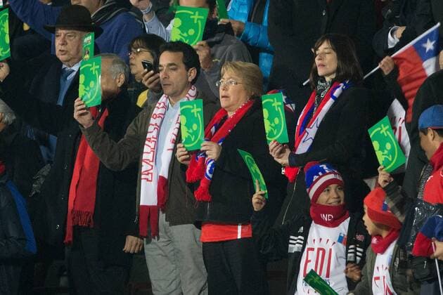 (150616) -- SANTIAGO, June, 2015 -- President of Chile Michelle Bachelet (C) attends the Group A match between Chile and Mexico at the Copa America 2015, at the National Stadium, in Santiago, Chile, on June 15, 2015. ) (ce) (SP)CHILE-SANTIAGO-COPA AMERICA-CHILE VS MEXICO PEDROxMERA 