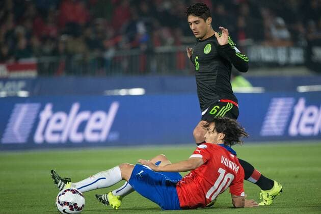 (150616) -- SANTIAGO, June, 2015 -- Jorge Valdivia (Bottom) of Chile vies for the ball with Javier Guemez of Mexico during the the Group A match of the Copa America 2015, at the National Stadium, in Santiago, Chile, on June 15, 2015. The match ended with a 3-3 draw. ) (ce) (SP)CHILE-SANTIAGO-COPA AMERICA-CHILE VS MEXICO PEDROxMERA 
