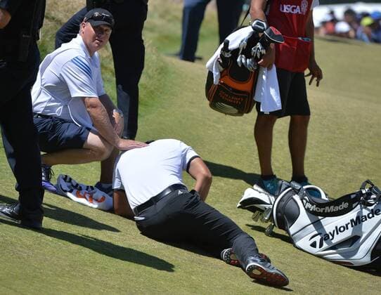 Jason Day of Australia lies collapsed on the ground as caddie Colin Swatton crouches over him on the ninth hole, his last of the day, in the second round of the 115th U.S. Open Championship at Chambers Bay on June 19, 2015 in University Place, Washington. Day recovered to putt out and finish his round.  SEA20150619036 KEVINxDIETSCH