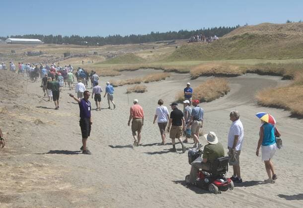 Aktuell Golf, US Open, Tag 3 An official directs a scooter stuck in the sand along the second hole to a different route during the third round of the 115th U.S. Open Championship at Chambers Bay on June 20, 2015 in University Place, Washington. The nature of the Chambers Bay course makes it difficult fans to follow their favorite golfers.  SEA20150620003 TERRYxSCHMITT