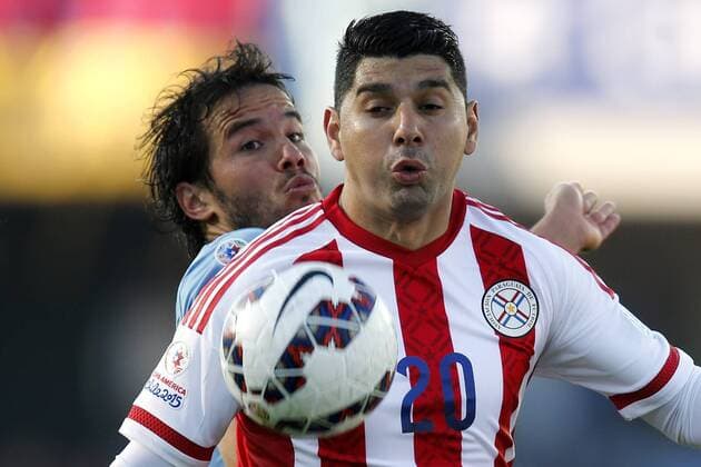 Football , Uruguay v Paraguay. Copa America Championship 2015 . Paraguay s player Nestor Ortigoza, right, battles for the ball against Alvaro Gonzalez of Uruguay during the group B football match of the 2015 Copa America at the La Portada stadium in Santiago.. 20 06 2015 Andres Pina Photosport Uruguay v Paraguay, Copa America 2015. 