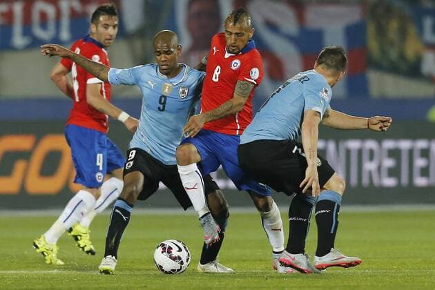 Chile v Uruguay. Copa America 2015 . Chile s Arturo Vidal, right , battles for the ball against Diego Rolan of Uruguay during the match of quarter finals of the 2015 Copa America at La Serena stadium. Santiago, Chile. 24 06 2015 Marcelo Hernandez Photosport Chile v Uruguay, Copa America 2015. 
