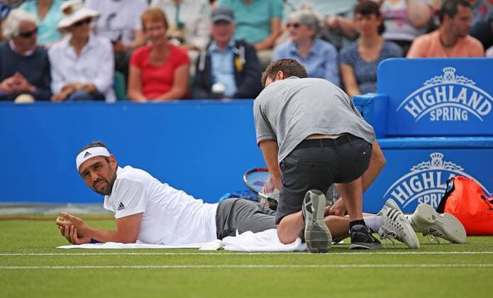 Aktuell Tennis, ATP Turnier in Nottingham 26.06.2015. Nottingham, England. Aegon Nottingham Open Tennis Tournament. Marcos Baghdatis (Cyprus) receiving treatment from the physiotherapist after feeling a strain in his lower leg. He subsequently retired allowing his opponent Denis Istomin (UZB) to progress into the final xDavidxKissmanx  ActionPlus11635182