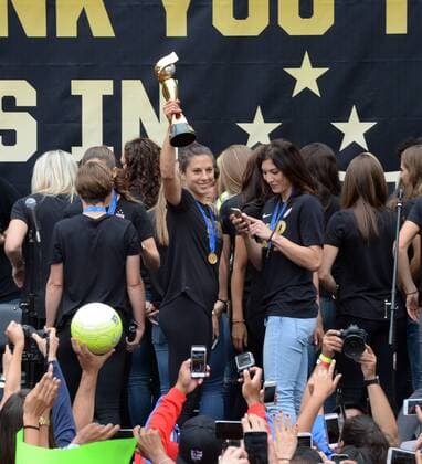 The United States of America women s soccer team lead by Carli Lloyd (holding trophy) celebrate their 2015 Women s World Cup victory during a rally at Microsoft Square in Los Angeles on July 7, 2015.  LAP2015060705 JIMxRUYMEN