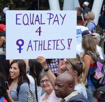 A fans holds up a sign addressing the issue of equal pay during a rally to celebrate the 2015 Women s World Cup at Microsoft Square in Los Angeles on July 7, 2015. According to Jezebel, the winning USA female soccer team is paid 40 times less than their losing male counterparts.  LAP2015070710 JIMxRUYMEN