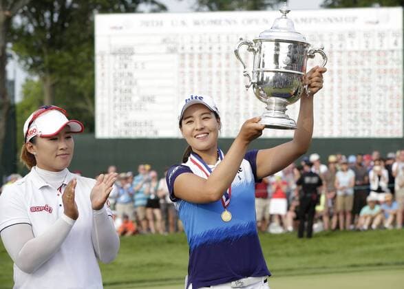 In Gee Chun of Korea holds up the championship trophy standing next to runner up Amy Yang of Korea on the 18th green in the final round of the LPGA Golf Damen U.S. Women s Open Championship at Lancaster Country Club in Lancaster, PA on July 12, 2015. Chun wins the U.S. Women s Open and her first LPGA major championship with a score of 8 under par.  NYP20150712127 JOHNxANGELILLO