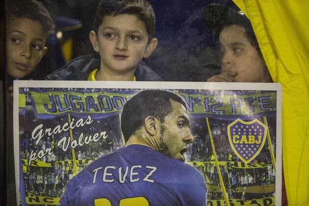 Fans hold a placard during the presentation of Argentinean soccer player Carlos Tevez as Boca Juniors new player in the Alberto J. Armando Stadium in the city of Buenos Aires, capital of Argentina, on July 13, 2015. Martin Zabala) (SP)ARGENTINA-BUENOS AIRES-SOCCER-TEVEZ e MARTINxZABALA 