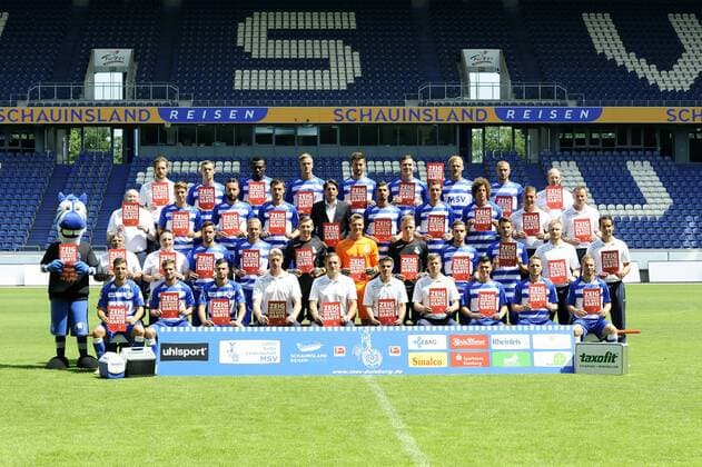 Fussball, 2. Bundesliga, Deutschland, Herren, Porträttermin Saison 2015 2016, Mannschaftsbild, Kader; MSV Duisburg mit Zeig Rassismus die rote Karte -Karten. 1. Reihe v.li.: Kevin Wolze, Nico Klotz, Andreas Wiegel, Torwarttrainer Sven Beuckert, Athletiktrainer Andreas Tappe, Cheftrainer Gino Lettieri, Co-Trainer Daniel Felgenhauer, Domink Behr, Martin Dausch, Pierre De Wit. 2. Reihe v.li.: Maskottchen Ennatz, Zeugwart Manni Piwonski, Zeugwart Sascha Jordan, Matthias Kühne, Dennis Grote, Maurice Schumacher, Michael Ratajczak, Marcel Lenz, Ahmet Engin, Tim Albutat, Physiotherapeut Andreas Bühren, Physiotherapeut Sven Bockermann. 3. Reihe v.li.: Zeugwart Peter Lindner, Steffen Bohl, Zlatko Janjic, Branimir Bajic, Sportdirektor Ivo Grlic, Enis Hajri, Thomas Bröker, Rolf Feltscher, Mannschaftsarzt Dr. Christian Schoepp, Physiotherapeut Will aan den Boom. 4. Reihe v.li.: Mannschaftsarzt Dr. Falk Ullerich, Stanislav Iljutcenko, Kingsley Onuegbu, Thomas Meißner, Dustin Bomheuer, Kevin Scheidhauer, Sascha Dum, Simon Brandstetter, Busfahrer Martin Kuppers.