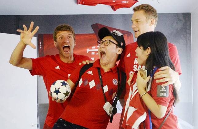 Thomas Müller, left, and Manuel Neuer, second right, of FC Bayern München pose with Chinese football fans at a promotional event by Adidas in Guangzhou ctiy, south China s Guangdong province, 22 July 2015. Thomas Müller, Manuel Neuer pair up to fascinate football fans in Guangzhou  20150723_42941
