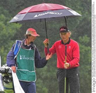 26.07.2015. Sunningdale, Berkshire, England. Seniors Open Golf Tournament Round 4. Bernhard Langer (GER) shields from the rain xJonxBromleyx  ActionPlus11644324