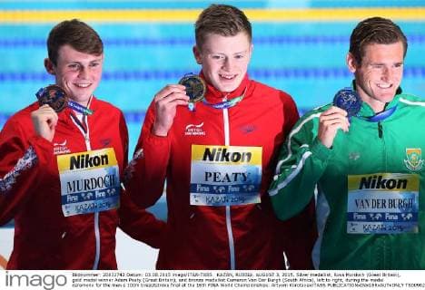 KAZAN, RUSSIA. AUGUST 3, 2015. Silver medallist, Ross Murdoch (Great Britain), gold medal winner Adam Peaty (Great Britain), and bronze medallist Cameron Van Der Burgh (South Africa), left to right, during the medal ceremony for the men s 100m breaststroke final at the 16th FINA World Championships. Artyom Korotayev TASS  TS00902B