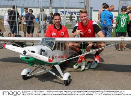 Josef Schmidt (Rasenhelfer des FC Augsburg) und Hobby-Flugzeugmodell-Bauer hat ein FCA-Flugzeug konstruiert. Daumen hoch dafür von Jan-Ingwer Callsen-Bracker (FC Augsburg 18, re.) FC Augsburg, Training, Saison 2015 - 2016, 11.08.2015