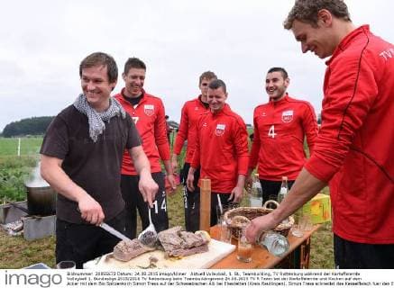 Aktuell Volleyball, 1. BL, Teambuilding, TV Rottenburg während der Kartoffelernte Volleyball 1. Bundesliga 2015 2016 TV Rottenburg beim Teambuildingevent 24.08.2015 TV R Team bei der Kartoffelernte und Kochen auf dem Acker mit dem Bio Spitzenkoch Simon Tress auf der Schwaebischen Alb bei Ehestetten (Kreis Reutlingen). Simon Tress schneidet das Kesselfleisch fuer den Eintopf beobachtet von Sven Metzger , Friederich Nagel , Co-Trainer Karsten Haug, Federico Cipollone und Lars Wilmsen (v.li.) 