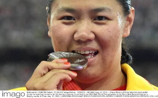 (150827) -- BEIJING, Aug. 27, 2015 -- Zhang Wenxiu of China bites her silver medal during the awarding ceremony for the women s hammer throw final at the 2015 IAAF World Championships at the Bird s Nest National Stadium in Beijing, capital of China, Aug. 27, 2015. ) (SP)CHINA-BEIJING-IAAF WORLD CHAMPIONSHIPS--WOMEN S HAMMER THROW-AWARDING CEREMONY (CN) LixWen 