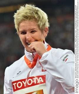 (150827) -- BEIJING, Aug. 27, 2015 -- Anita Wlodarczyk of Poland bites her gold medal during the awarding ceremony for the women s hammer throw final at the 2015 IAAF World Championships at the Bird s Nest National Stadium in Beijing, capital of China, Aug. 27, 2015. Wlodarczyk claimed the title of the event with 80.85 metres. ) (SP)CHINA-BEIJING-IAAF WORLD CHAMPIONSHIPS--WOMEN S HAMMER THROW-AWARDING CEREMONY (CN) LixWen 