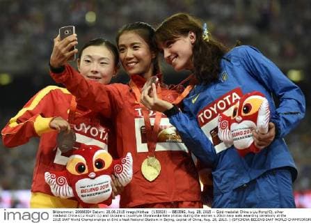 (150828) -- BEIJING, Aug. 28, 2015 -- Gold medalist China s Liu Hong(C), silver medalist China s Lv Xiuzhi (L) and Ukraine s Lyudmyla Olyanovska take photos during the women s 20km race walk awarding ceremony at the 2015 IAAF World Championships at Bird s Nest National Stadium in Bejing, capital of China, Aug. 28, 2015. ) (SP)CHINA-BEIJING-IAAF WORLD CHAMPIONSHIPS-WOMEN S 20KM RACE WALK AWARDING CEREMONY (CN) GongxLei 