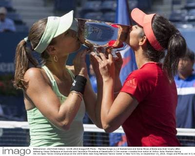 Martina Hingis (L) of Switzerland and Sania Mirza of India kiss their trophy after defeating Casey Dellacqua of Australia and Yaroslava Shvedova of Kazakhstan in the woman s double final match at Arthur Ashe Stadium during the US Open Tennis Championships at the USTA Billie Jean King National Tennis Center in New York City on September 13, 2015. Hingis and Mirza won 6-3, 6-3.  NYP20150913304 MONIKAxGRAFF