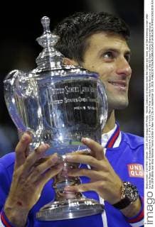 Novak Djokovic of Serbia holds the trophy and looks up at the cheering crowd after he beat Roger Federer of Switzerland 6-4, 5-7, 6-4, 6-4 in the Men s Final in Arthur Ashe Stadium at the US Open Tennis Championships at the USTA Billie Jean King National Tennis Center in New York City on September 13, 2015.  NYP20150913830 RAYxSTUBBLEBINE