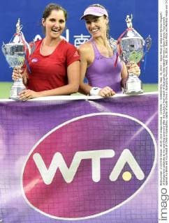 (150926) -- GUANGZHOU, Sept. 26, 2015 -- Sania Mirza of India and Martina Hingis(R) of Switzerland celebrate at the awarding ceremony after the double s final match of Guangzhou Internationl Women s Open Tennis Tournament against Xu Shilin and You Xiaodi of China in Guangzhou, capital of south China s Guangdong Province, Sept. 26, 2015. Sania Mirza and Martina Hingis won 2-0 and claimed the title. ) (SP)CHINA-GUANGZHOU-TENNIS-INTERNATIONAL WOMEN S OPEN-FINAL LiangxXu 
