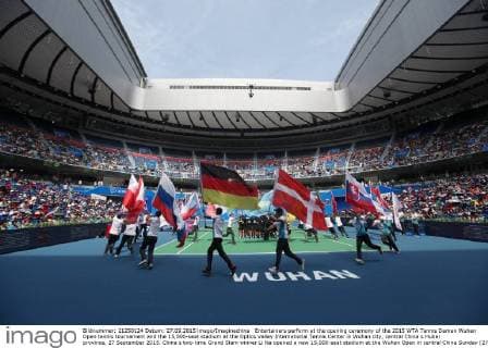 Entertainers perform at the opening ceremony of the 2015 WTA Tennis Damen Wuhan Open tennis tournament and the 15,000-seat stadium at the Optics Valley International Tennis Center in Wuhan city, central China s Hubei province, 27 September 2015. China s two-time Grand Slam winner Li Na opened a new 15,000-seat stadium at the Wuhan Open in central China Sunday (27 September 2015) to huge cheers from her hometown fans. The new stadium has been built on the back of Li s career success, she was the first Asian to win a Grand Slam singles, that saw the popularity of tennis surge in China. Huge applause echoed through the stadium as Li, now retired, stepped onto the court wearing a red dress and was joined by the tournament s defending champion Petra Kvitova to open the new stadium officially. Similar in capacity to Wimbledon s centre court, the new stadium is dwarfed only by the US Open s Arthur Ashe stadium which has a capacity of 23,000. It has a retractable roof and a metal and glass structure reminiscent of the iconic bird s nest stadium in Beijing, the centrepiece of the 2008 Olympics. Li Na thrills fans at Wuhan stadium opening  20150927_66315