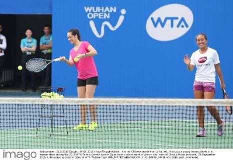 Retired Chinese tennis star Li Na, left, instructs a young tennis player in a master class during the 2015 WTA Tennis Damen Wuhan Open tennis tournament in Wuhan city, central China s Hubei province, 29 September 2015. Li Na plays up master class at WTA Wuhan Open  20150929_34418