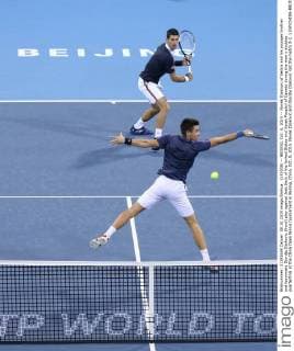 (151008) -- BEIJING, Oct. 8, 2015 -- Novak Djokovic of Serbia and his younger brother and teammate Djordje Djokovic (front) play against Jack Sock of the United States and Vasek Pospisil of Canada during the men s doubles quarterfinal at the China Open tennis tournament in Beijing, China, Oct. 8, 2015. Novak Djokovic and Djordje Djokovic lost the match 0-2. ) (SP)CHINA-BEIJING-TENNIS-CHINA OPEN-MEN S DOUBLES-QUARTER FINAL XingxGuangli 