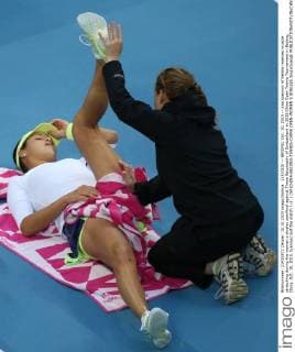 (151010) -- BEIJING, Oct. 10, 2015 -- Ana Ivanovic of Serbia receives muscle stretching during the women s singles semifinal against Timea Bacsinszky of Switzerland at 2015 China Open Tennis Tournament in Beijing, China, Oct. 10, 2015. Ivanovic lost the match 1-2. ) (SP)CHINA-BEIJING-TENNIS-CHINA OPEN-WOMEN S SINGLES XingxGuangli 