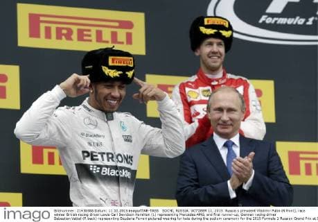 SOCHI, RUSSIA. OCTOBER 11, 2015. Russia s president Vladimir Putin (R front), race winner British racing driver Lewis Carl Davidson Hamilton (L) representing Mercedes AMG, and first runner-up, German racing driver Sebastian Vettel (R back) representing Scuderia Ferrari pictured wearing fur hats during the podium ceremony for the 2015 Formula 1 Russian Grand Prix at Sochi s Olympic Park. Mikhail Japaridze TASS  66018646