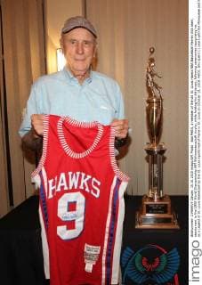 Bob Pettit, a member of the old St. Louis Hawks NBA Basketball Herren USA team, stands next to the 1958 World Championship WM Weltmeisterschaft trophy, while holding his old jersey, following ceremonies recognizing his as a Legend of St. Louis Basketball by the St. Louis Sports Hall of Fame in St. Louis on October 15, 2015. Pettit, who spent 11 years with the Milwaukee and St. Louis Hawks was the first player in the NBA to top 20,000 points and remains the only player in the NBA (1958) to score 50 points in an NBA playoff game.  SLP2015101501 BILLxGREENBLATT