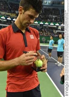 Novak Djokovic of Serbia, left, signs an autograph on a tennis ball after defeating Bernard Tomic of Australia in their quarter-final match of the men s singles during the 2015 Shanghai Rolex Masters tennis tournament in Shanghai, China, 16 October 2015. Novak Djokovic of Serbia defeated Bernard Tomic of Australia 2-0 (7-6 6-1) in their quarter-final match of the men s singles during the 2015 Shanghai Rolex Masters tennis tournament in Shanghai, China, 16 October 2015. Novak Djokovic kicks out Bernard Tomic to advance to semi-final at Shanghai Rolex Masters  20151016_36051