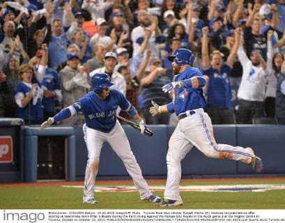 Toronto Blue Jays catcher Russell Martin (R) receives congratulations after scoring on teammate Kevin Pillar s double during the third inning against the Kansas City Royals in the ALCS game 3 at the Rogers Centre in Toronto, Canada on October 19, 2015.  TOR2015101918 KEVINxDIETSCH