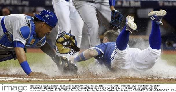 Oct. 19, 2015 - Toronto, CAN - Toronto Blue Jays center fielder Kevin Pillar dives for home plate past Kansas City Royals catcher Salvador Perez to score off a two-RBI hit by second baseman Ryan Goins during the second inning on Monday, Oct. 19, 2015, at Rogers Centre in Toronto. Kansas City Royals at Toronto Blue Jays - ZUMAm67_